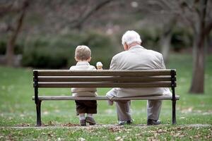 An older man and a young boy sitting on a bench photo