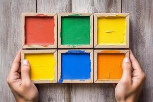 Hands holding a box with colored paint on it photo