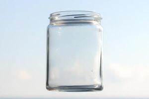 A clear jar sitting on a table with the ocean in the background photo