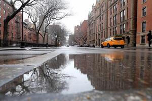 A yellow taxi cab is reflected in a puddle on a rainy day photo