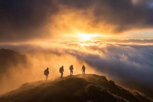 Three people stand on top of a mountain at sunset photo