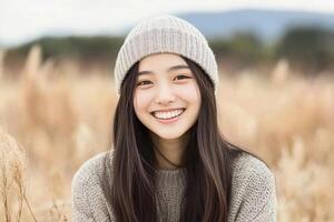 A young woman in a beanie smiling in a field photo
