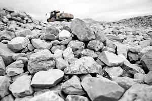 A bulldozer is sitting on top of a pile of rocks photo