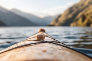 A canoe is seen in the water with mountains in the background photo
