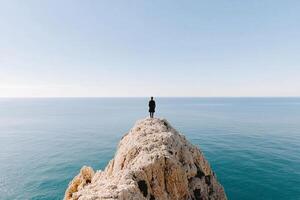 Man standing on top of cliff overlooking ocean by josef zajac for stocksy united photo
