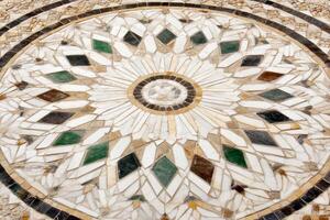 A circular mosaic tile with a flower design photo