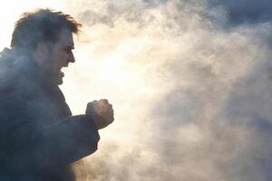 A man is standing in the smoke with his fist up photo