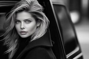 A woman in a black coat sitting in the back seat of a car photo