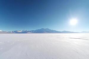 A large snow covered plain with mountains in the background photo
