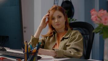 Bored woman in home office struggles while typing on computer and looking around video