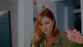 Woman analyzes data and graphs in a home office workspace during remote work video