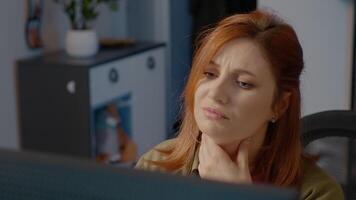 Woman in home office struggling with neck pain while working on computer video