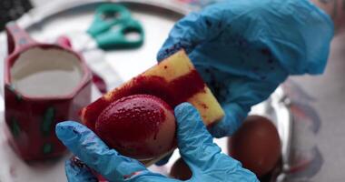 Easter egg painting through a detailed process involving red paints and creative techniques using sponge video