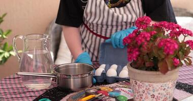 Gathering supplies for painting Easter eggs includes preparing eggs for boiling and setting up a workspace. Discover step of egg painting process with fun techniques. video