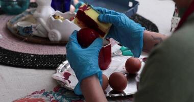 Easter egg painting, where red dyes and artistic skills bring eggs to life, making the celebration more vibrant and fun for everyone involved. video
