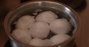 Boiling process of eggs essential for Easter eggs. White eggs boil in pan with hot water video