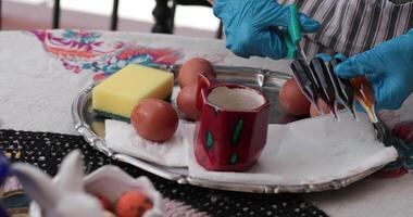 Explore the step of egg painting process featuring Easter eggs being decorated with vibrant colors. A diverse set of tools and materials showcases the creativity involved in this seasonal activity. video