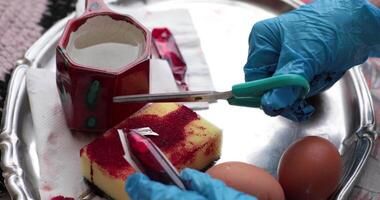 Different techniques are used in the egg painting process to create vibrant red Easter eggs. Explore various tools and methods for adding color and unique designs to each egg. video
