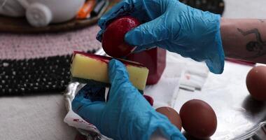 Colorful Easter eggs are created through the step of egg painting process using sponge and red paint, showcasing various techniques and vibrant colors for a joyful holiday tradition. video