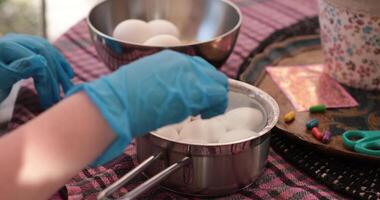 Watch as eggs are prepared for boiling in a delightful step of the egg painting process. Discover tips for creating beautiful Easter eggs with paint and colors. video