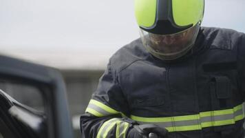 A courageous firefighter, equipped with specialized tools, heroically rescues people trapped in a car accident, displaying remarkable precision and bravery in the face of a life-threatening emergency video