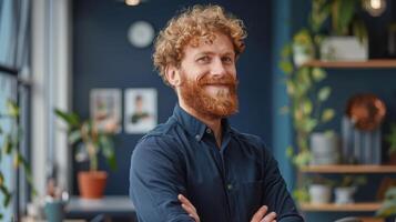 Portrait of a smiling man with red beard standing in an office photo