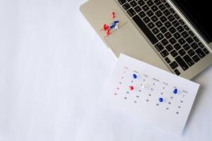 laptop with calendar pin on the table photo