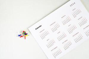 calendar with stack of colorful pin on the table photo