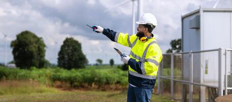 man in a yellow and black safety vest is pointing at something photo