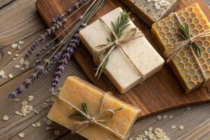 Soap bars with herbs and lavender on wooden table photo