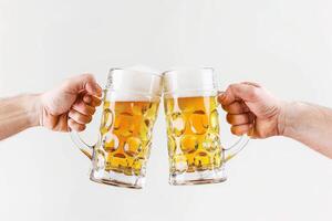 Two hands holding two beer mugs over a white background photo