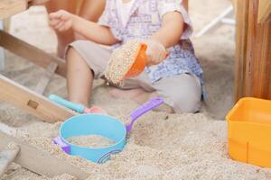 Cropped image of child boy have fun digging in the sand at the beach. photo