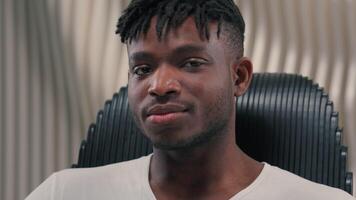 Portrait face futuristic confident serious gamer programmer calm African American man guy male in futurism modern white room studio looking at camera blinking eye flirting blink innovation technology video