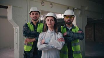 Confident glad Caucasian workers males architects builders men team coworkers controller woman crossing arms cooperation inspector looking at camera mechanics female smiling in construction teamwork video