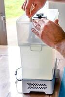 Man using a wash machine to clean a transparent 3d resin object, clean photo