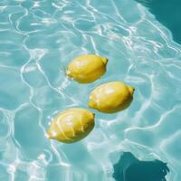 Three lemons floating in clear blue water, creating refreshing and vibrant scene photo