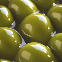 Glossy green olives submerged in liquid, reflecting light photo