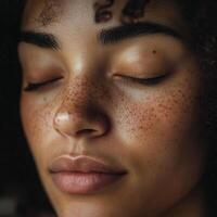 serene close up of woman with freckles and curly hair, eyes closed photo