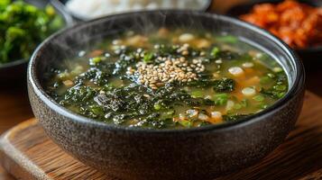 A steaming bowl of traditional Korean seaweed soup, with a side of rice and kimchi. 15 photo