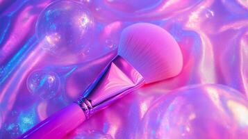 A makeup brush with large bubbles around it, against neon pink fabric. photo