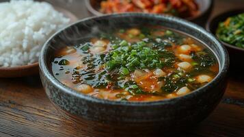 A steaming bowl of traditional Korean seaweed soup, with a side of rice and kimchi. 16 photo