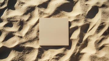 A blank square card on the sand, with shadows and ripples of sunlight. 10 photo