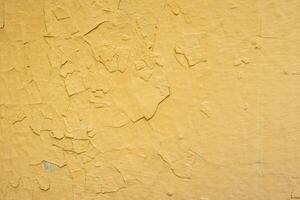 Background yellow wall colored with many layers of paint which is peeling photo