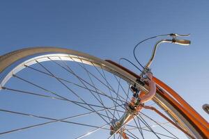 Part of bicycle with handlebar and wheel against blue sky. photo