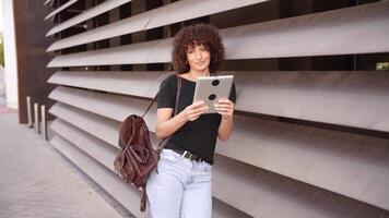A Young Woman Utilizing a Tablet While Outdoors, Set Against a Backdrop of Modern Architecture video