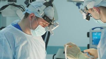 surgeons perform an operation and look through a mobile microscope 3 video