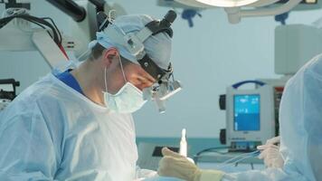 surgeons perform an operation and look through a mobile microscope 4 video