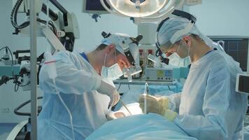 surgeons perform an operation and look through a mobile microscope 5 video