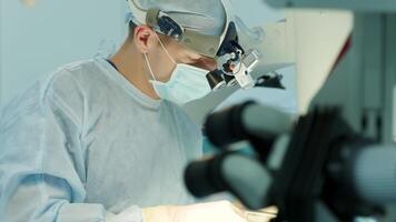 surgeons perform an operation and look through a microscope 5 video