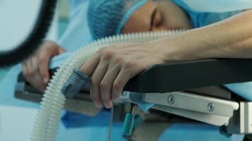 the patient lies on the operating table with a sensor on his finger 2 video